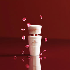 White bottle Olfazeta by Chogan Millésime N°161 under a shower of pink rose petals on a burgundy background